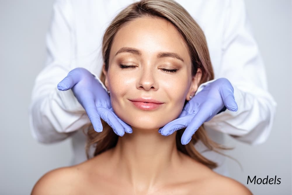 close-up of woman getting facial with dermatologist hands around face.