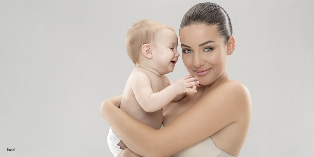 Mom with her baby on grey background